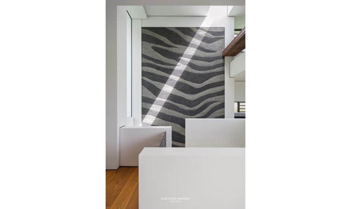 Eine Sichtbetonwand mit Zebramuster inszeniert eine Welt der kraftvollen Gegensätze.  Foto: © Alexander Brenner Architects
