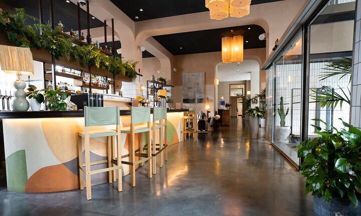 Besucher des trendigen Hotels in Barcelona werden von natürlichen Texturen, elegant geschwungenen Formen und belebenden Pflanzenarrangements begrüßt, sobald sie die Eingangshalle betreten.