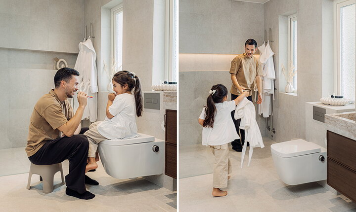 En vuxen och ett barn borstar tänderna i ett ljust badrum med vägghängd duschtoalett.