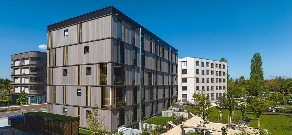 Hinter der markanten Holzfassade finden die Bewohner in 21 Wohnungen ein neues Zuhause. © Matthias Ibeler