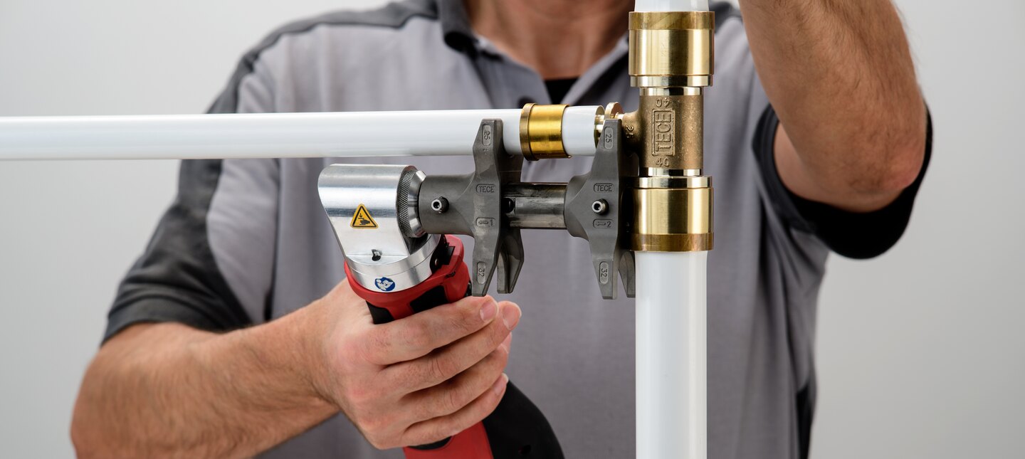 Das Rohr und der Fitting aus dem Rohrsystem TECEflex werden mit einem Axialpresswerkzeug verbunden.